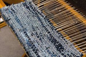 blue fabric strips and neutral yarn warp on loom